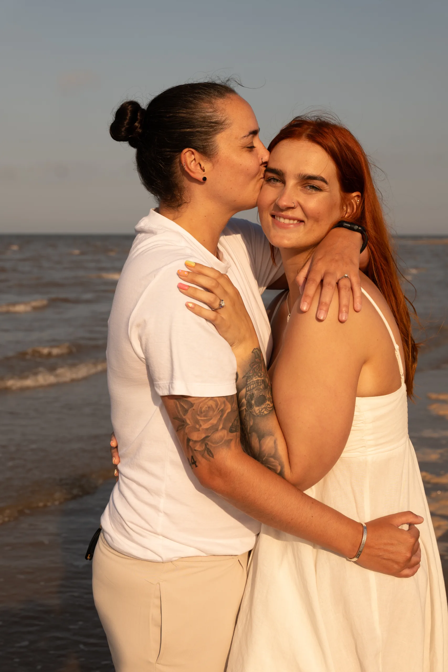 Two women embracing on the sandy shores of Cleethorpes, captured beautifully.