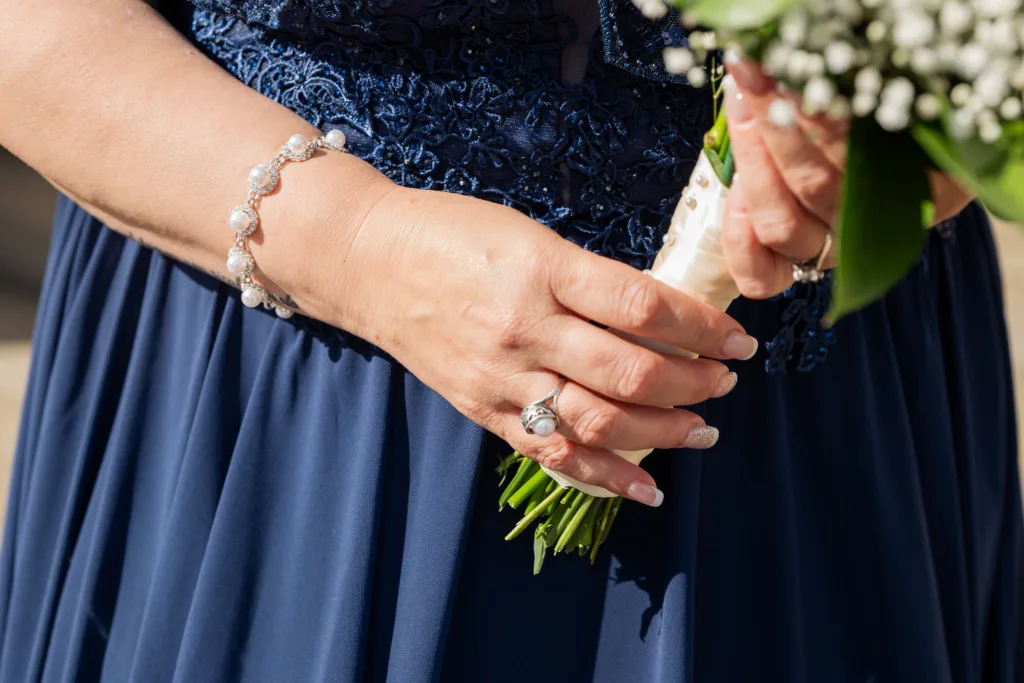 A bride in a blue dress holding a bouquet at Ross Castle.