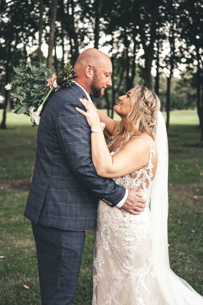 A bride and groom hugging in Laceby Manor, a picturesque park.