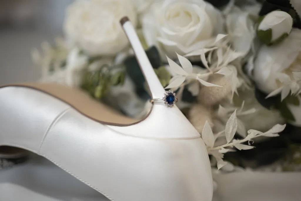 A bride's wedding shoe with a blue sapphire ring, showcased at Stallingborough Grange Hotel.