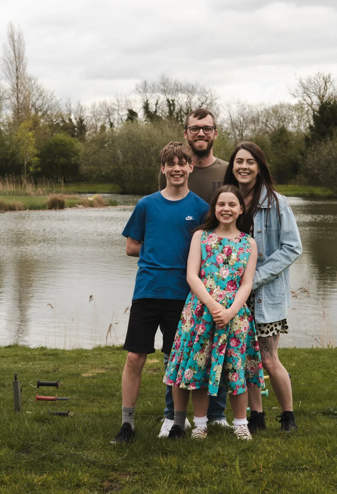 An outdoor photo of a family in front of a pond at Hall Farm Hotel.