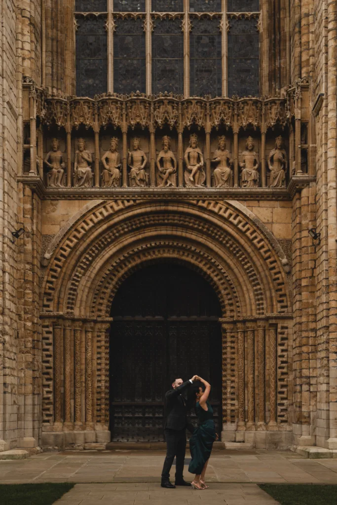 An engaged couple standing in front of Lincoln Cathedral.