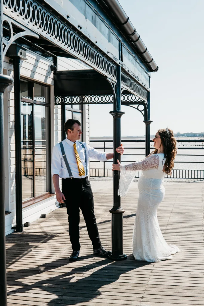 A bride and groom standing on a pier in Cleethorpes, capturing perfect moments for their wedding photography.