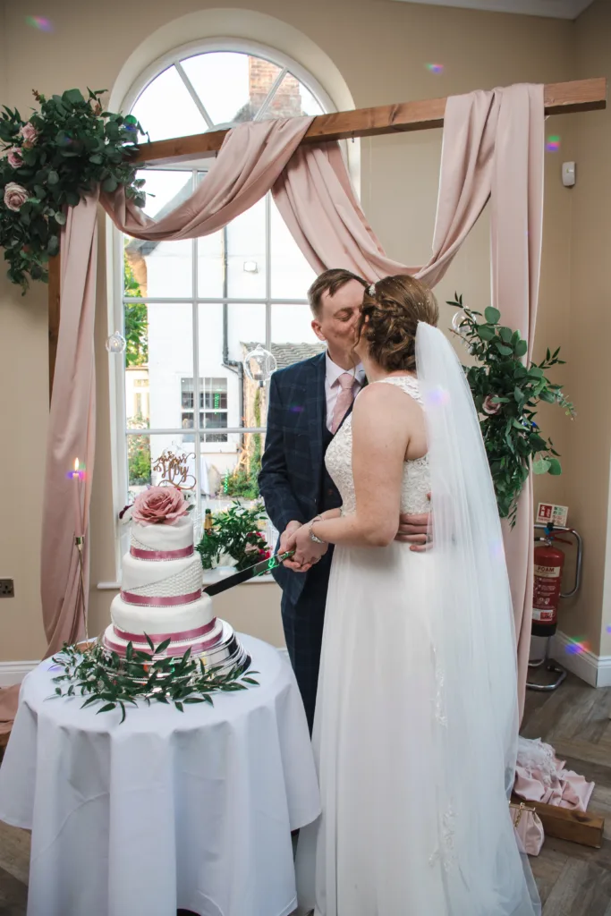 A bride and groom at Stallingborough Grange cutting their wedding cake.