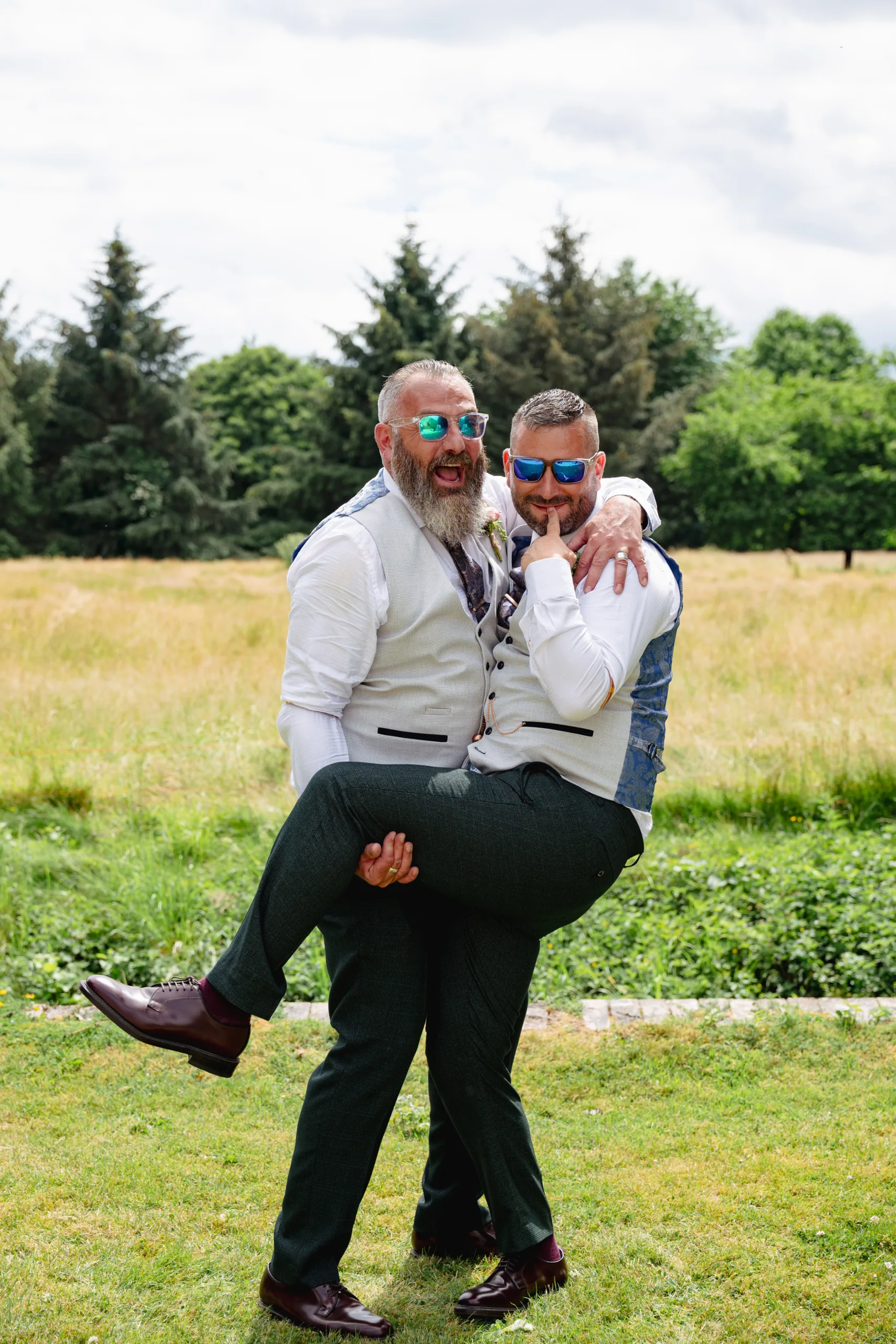 In this heartwarming family photo, two men embrace each other in a beautiful field.