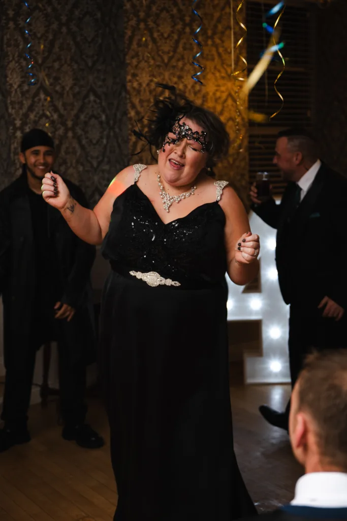 A woman in a black dress dancing at a family party.