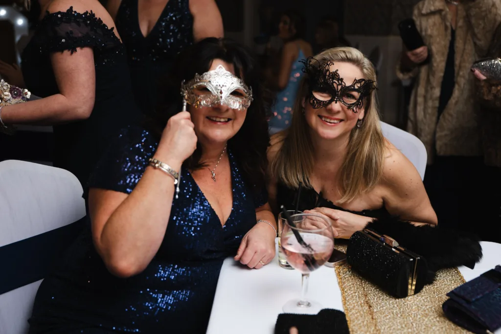 Two women wearing masks at a 40th birthday masquerade party in Cleethorpes.