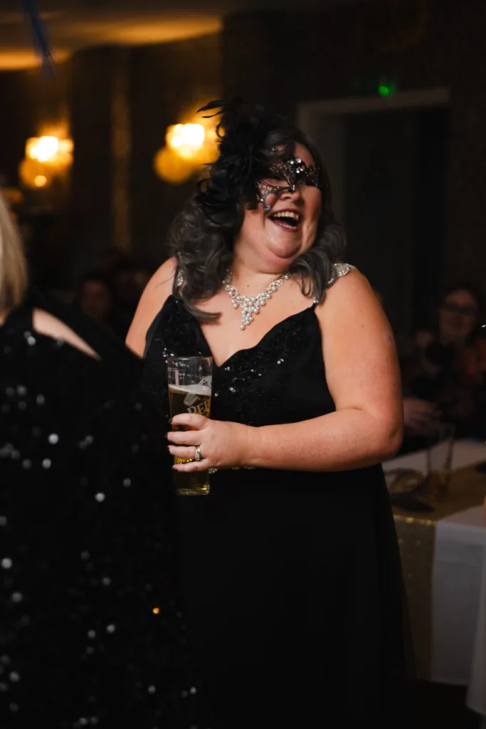 A woman in a black dress laughing at a family party in Cleethorpes.