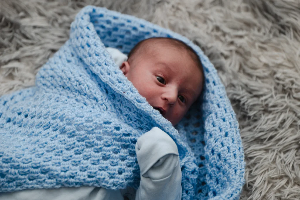 A newborn baby wrapped in a blanket.