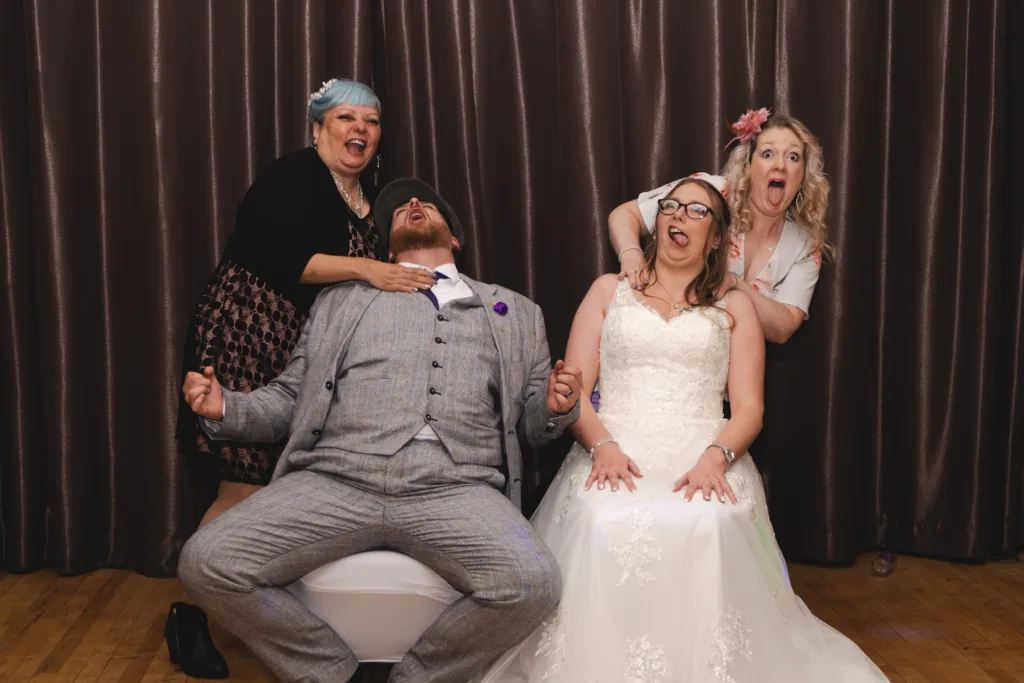 A bride and groom playing a photo roulette game in a photo booth.