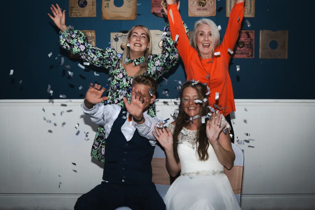 A group of bride and groom engaging in a confetti game.