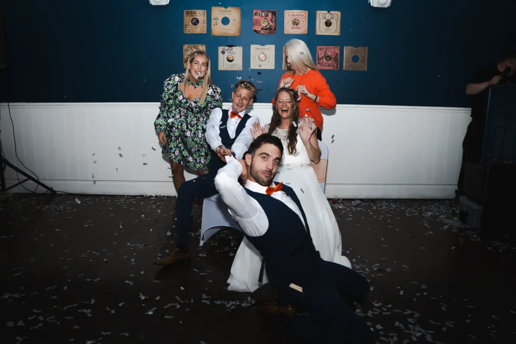 A group of people posing for a photo at a wedding.