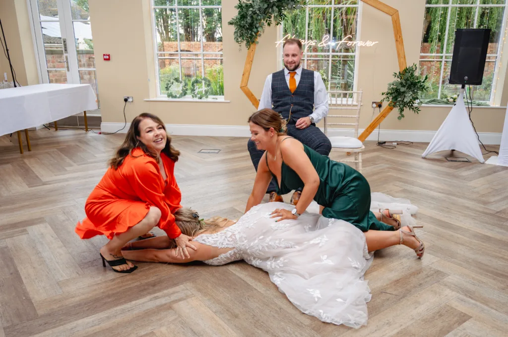 A bride and her bridesmaids playing a game of roulette on the floor, captured in a photo.