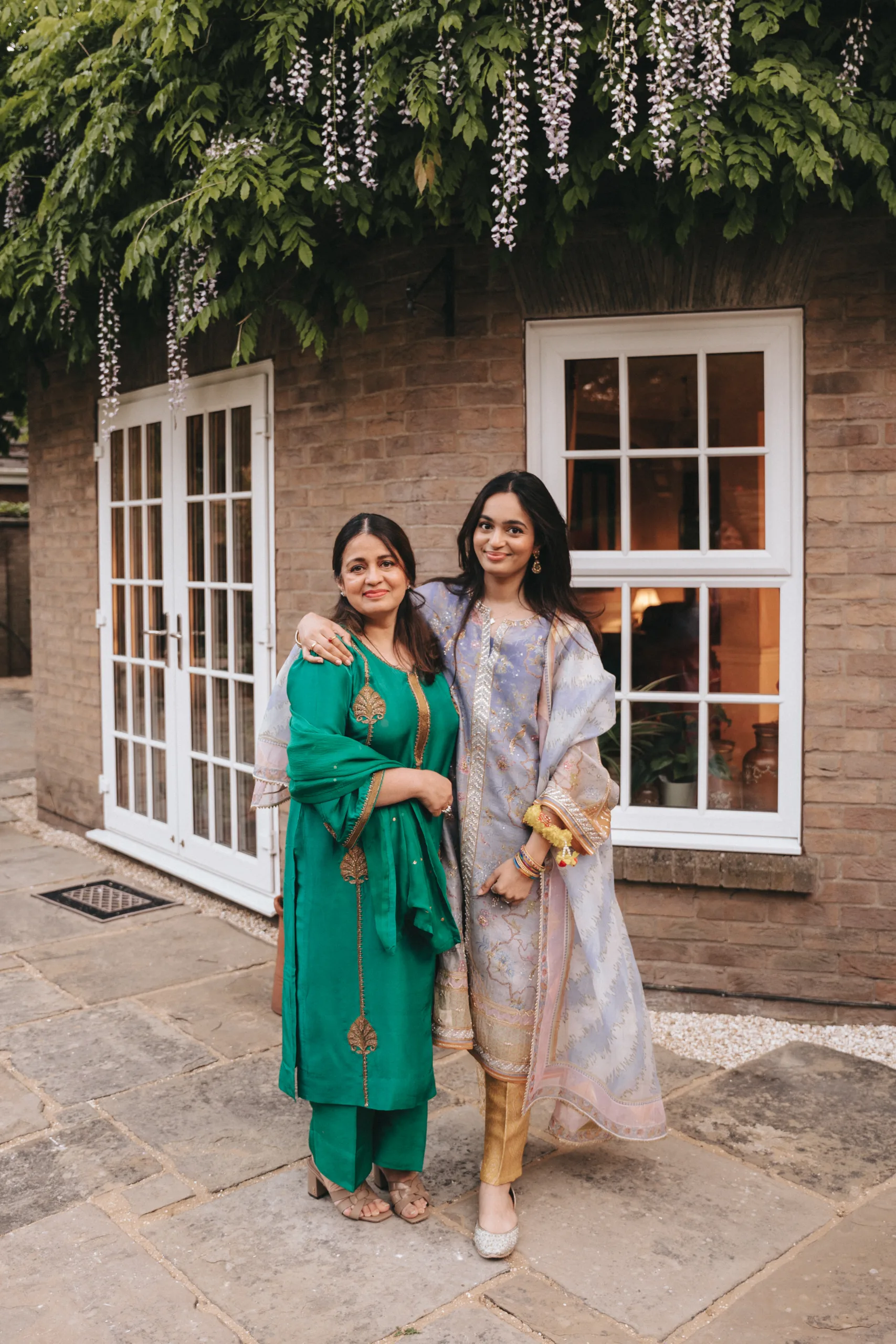 Two Indian women posing for a photo in front of a house in Yorkshire.