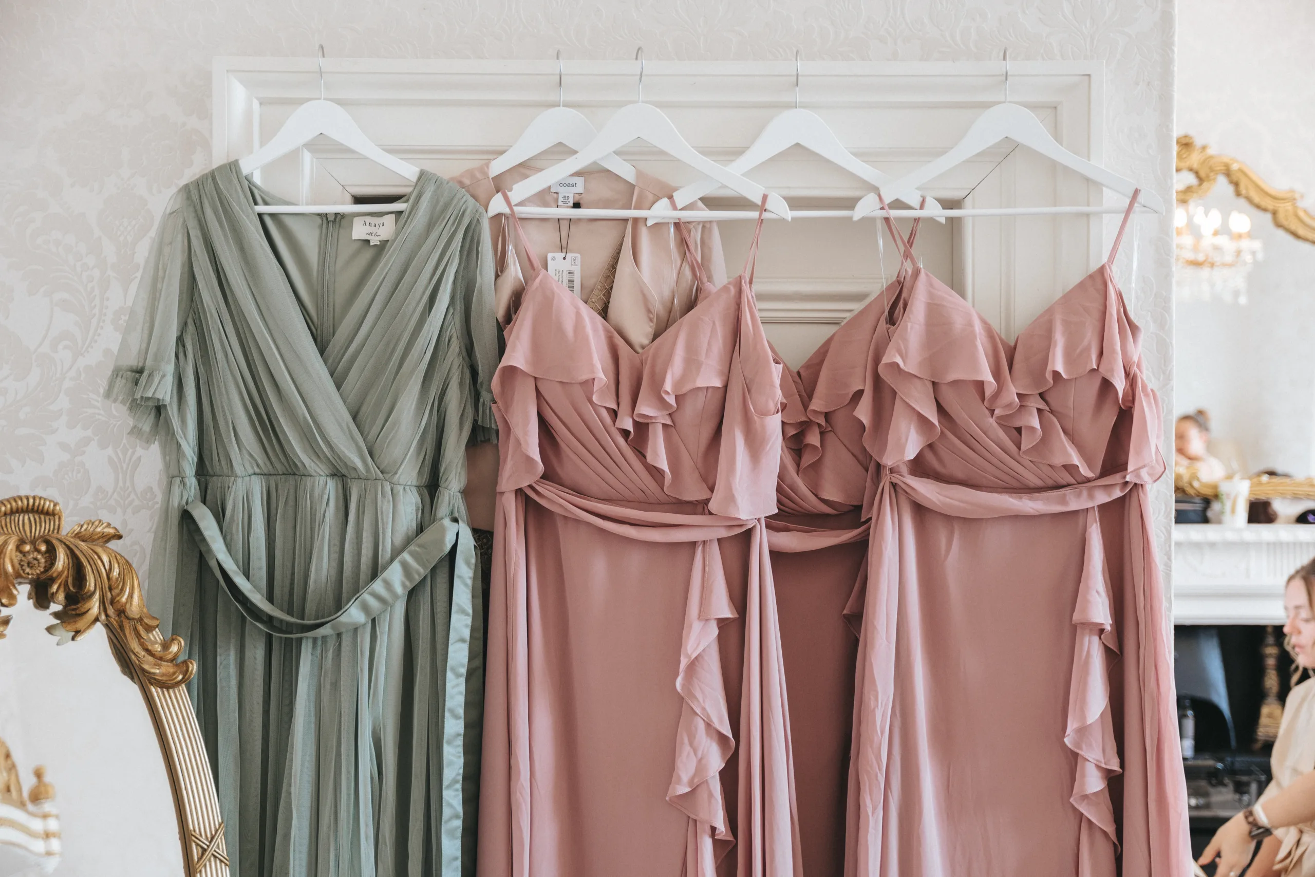 Bridesmaid dresses hanging in a room captured by a wedding photographer from Lincolnshire.