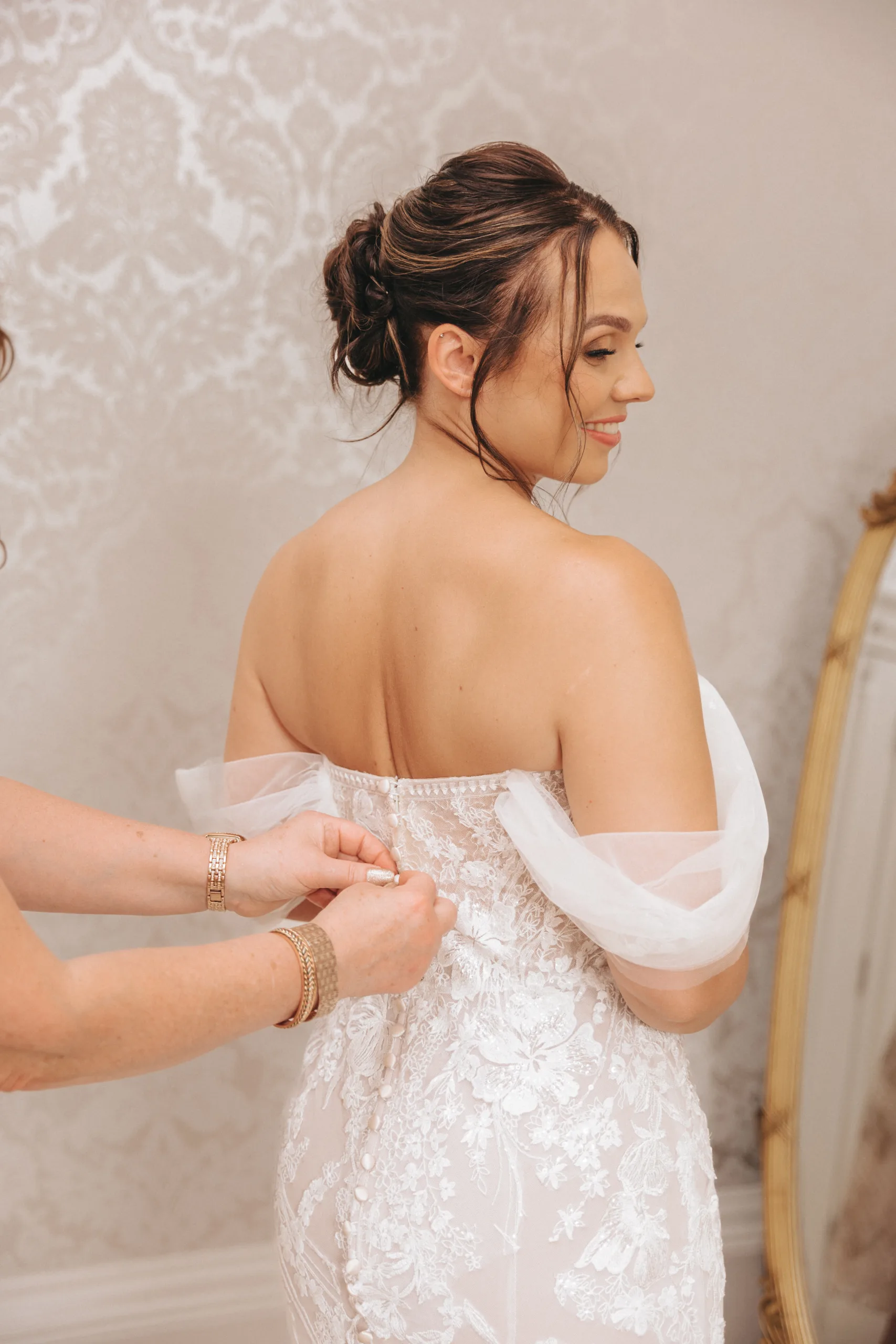 A bride getting ready in front of a mirror for her wedding, captured by a Yorkshire photographer.