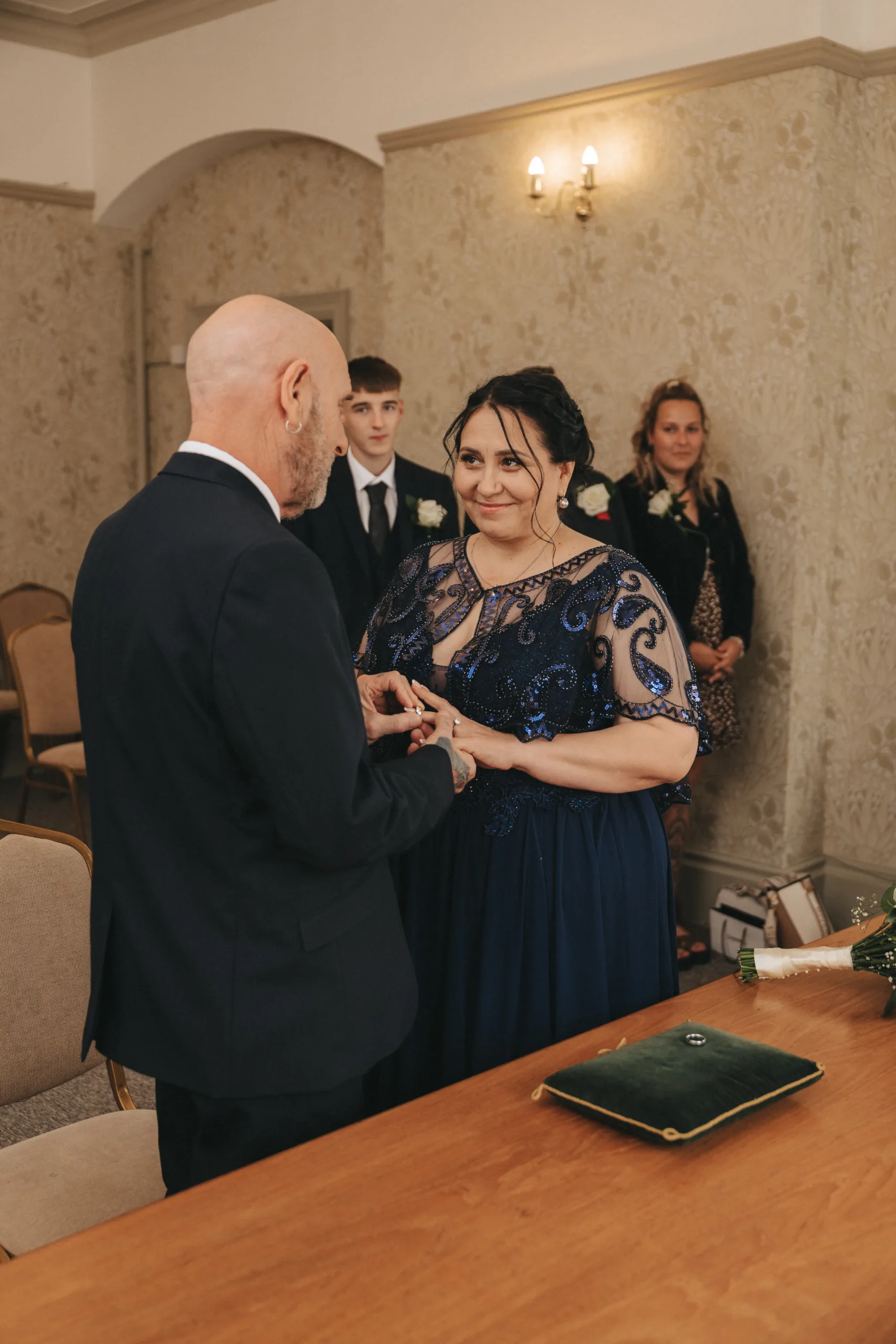 A Yorkshire bride and groom exchanging their wedding rings captured by a photographer.