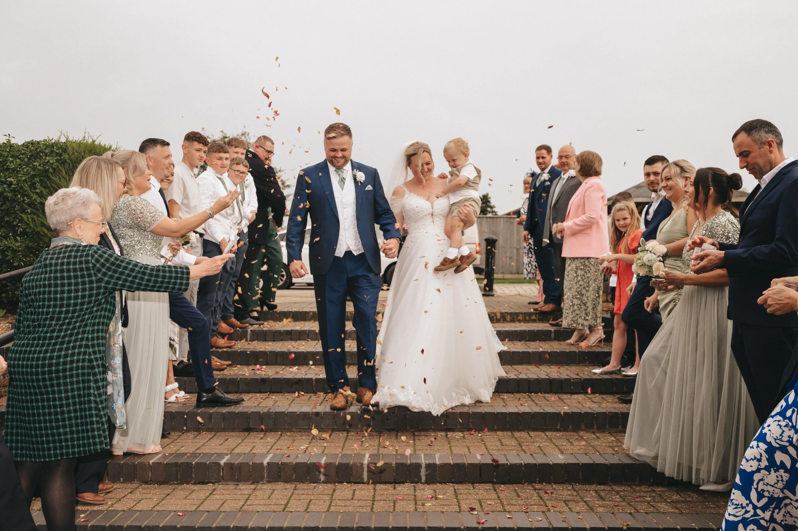 A wedding in Lincolnshire captured by a photographer, featuring the bride and groom walking down steps with confetti.
