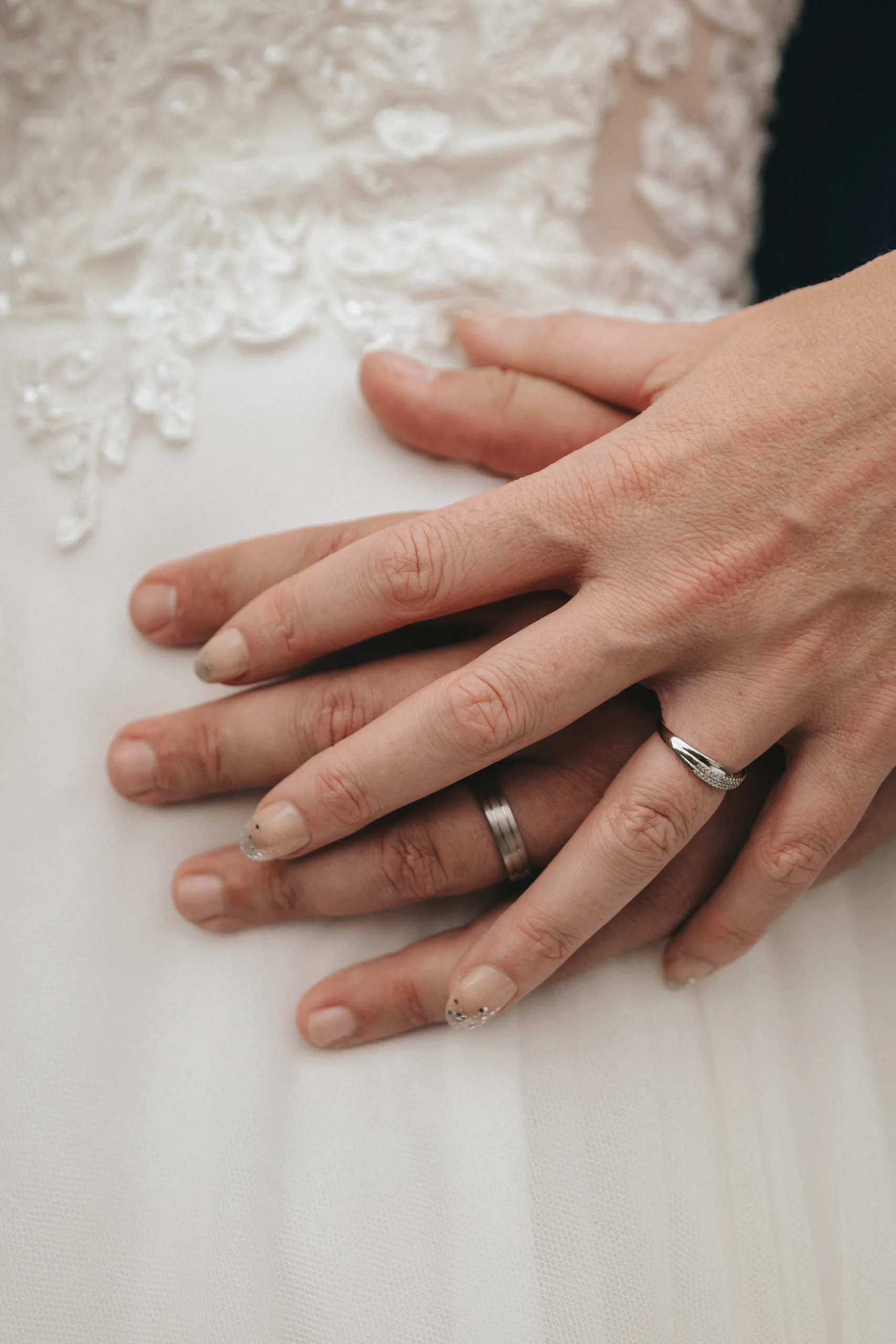 Close up photograph of a bride and groom's hands holding wedding rings in Lincolnshire.