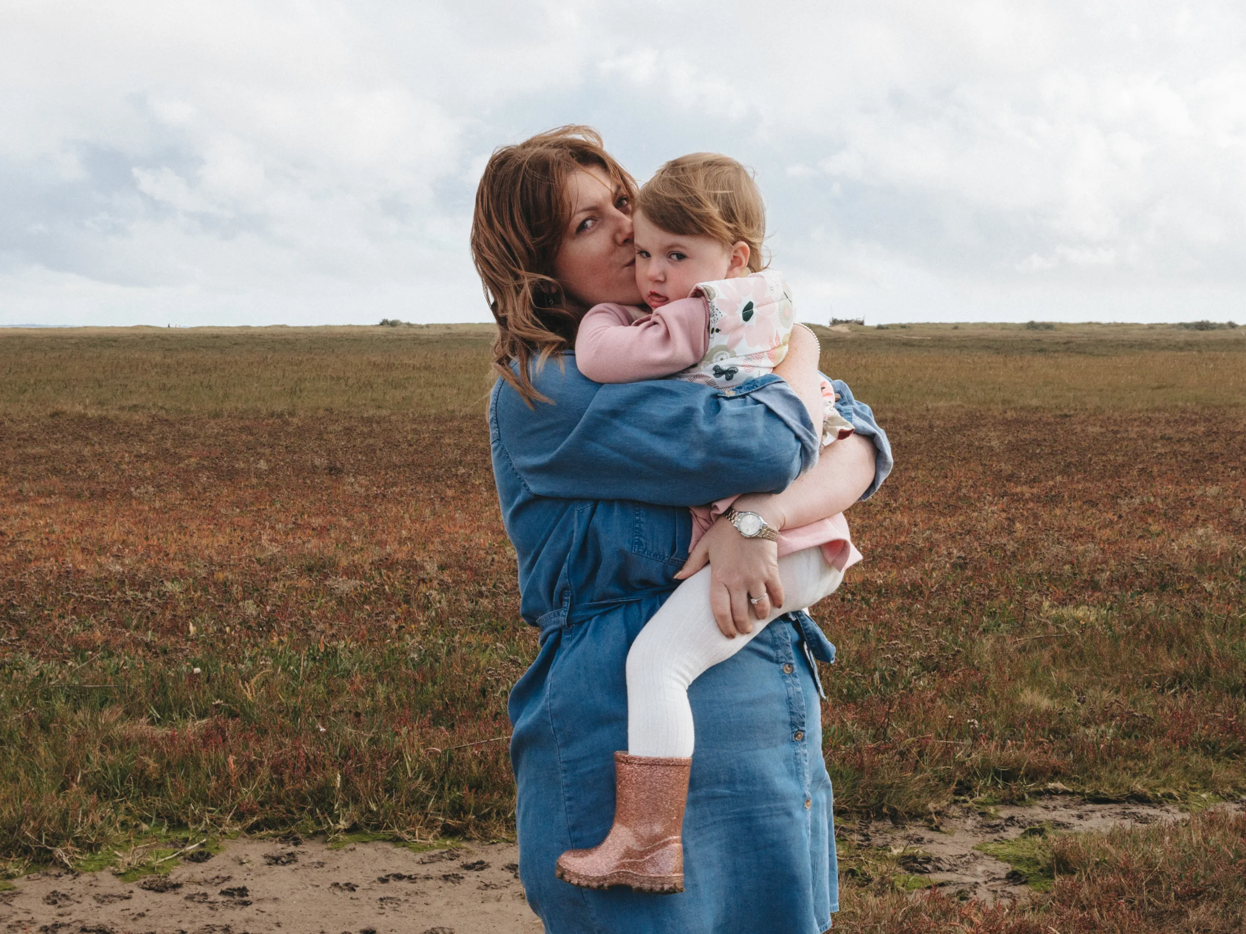A woman holding a child in the middle of a field in Yorkshire.
