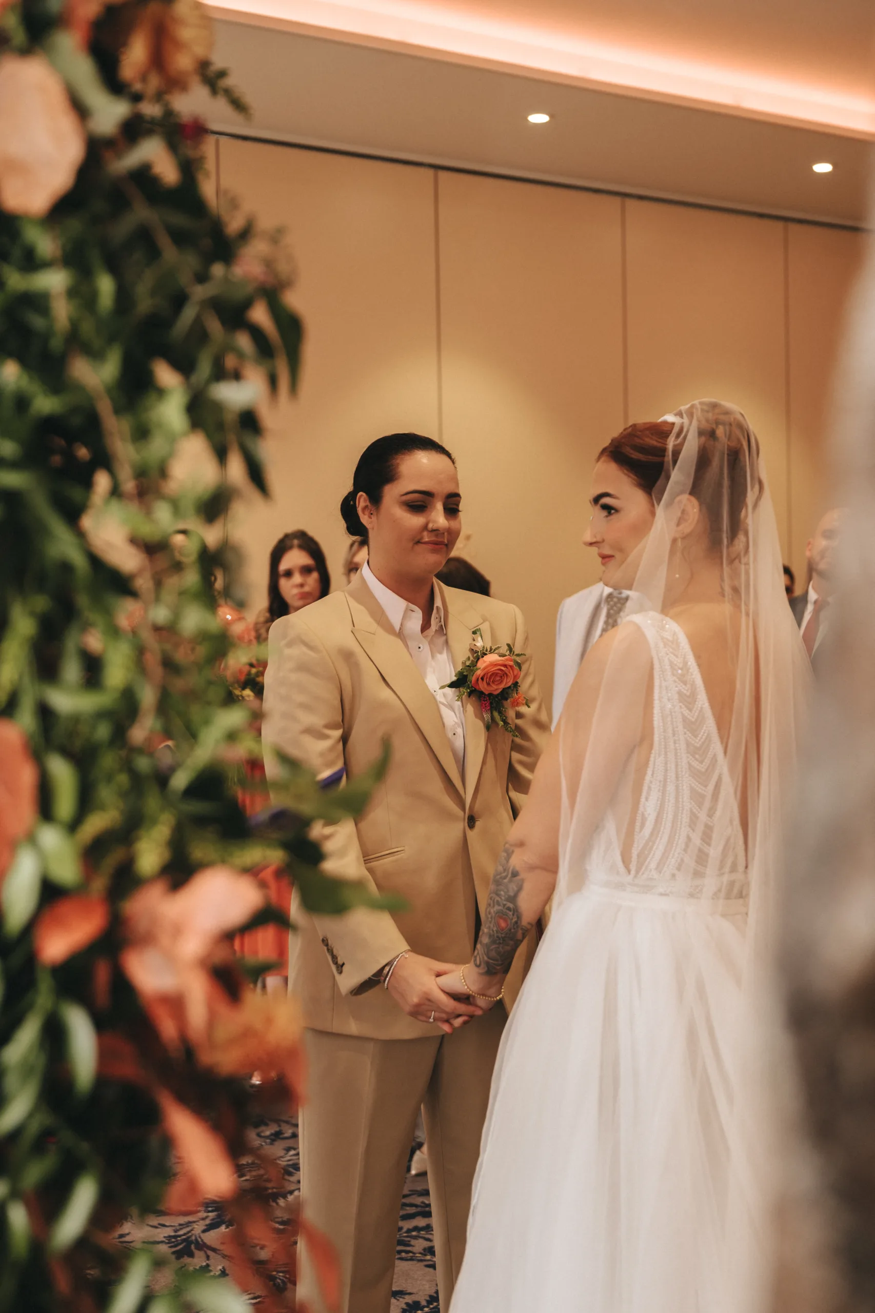 A bride and groom exchange vows at their wedding ceremony, captured by a photographer.