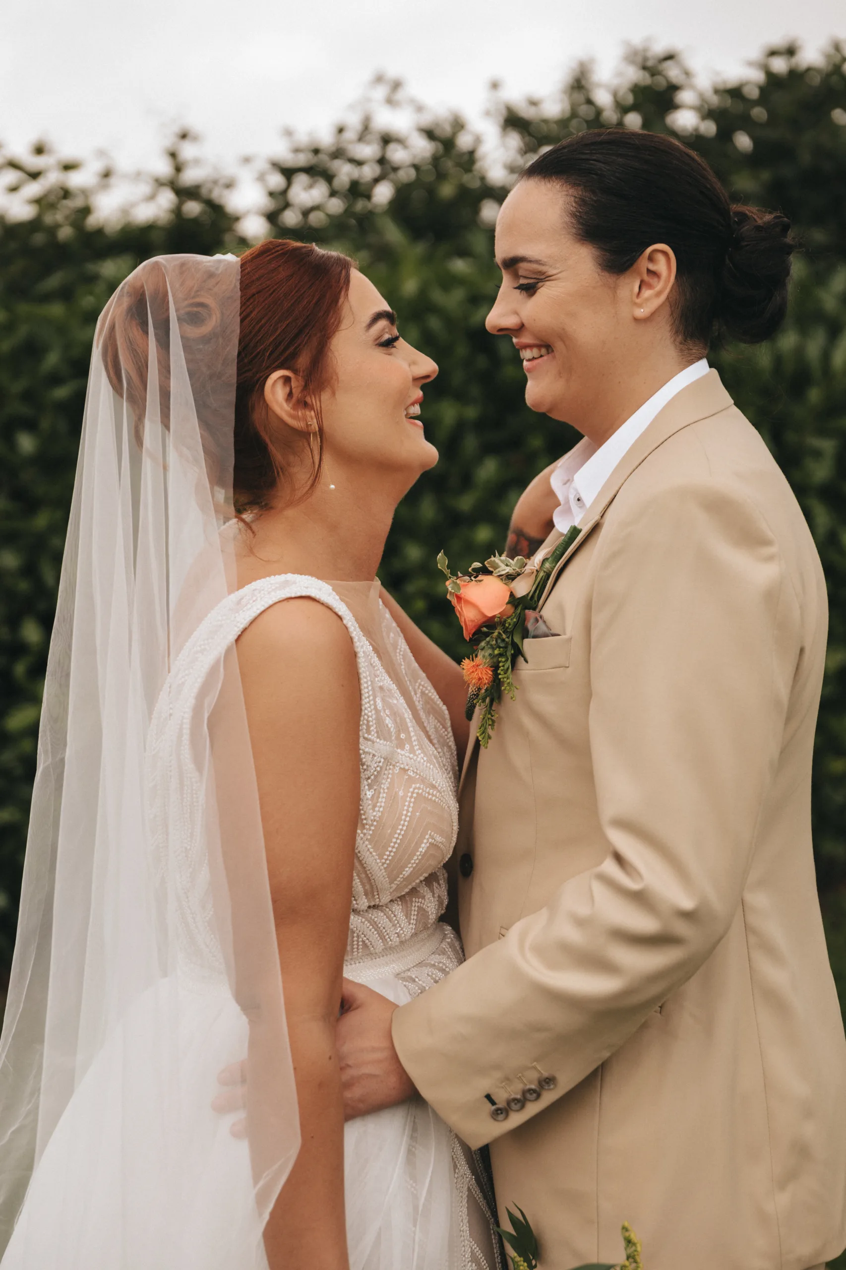 Two brides smiling at each other during a Yorkshire wedding.