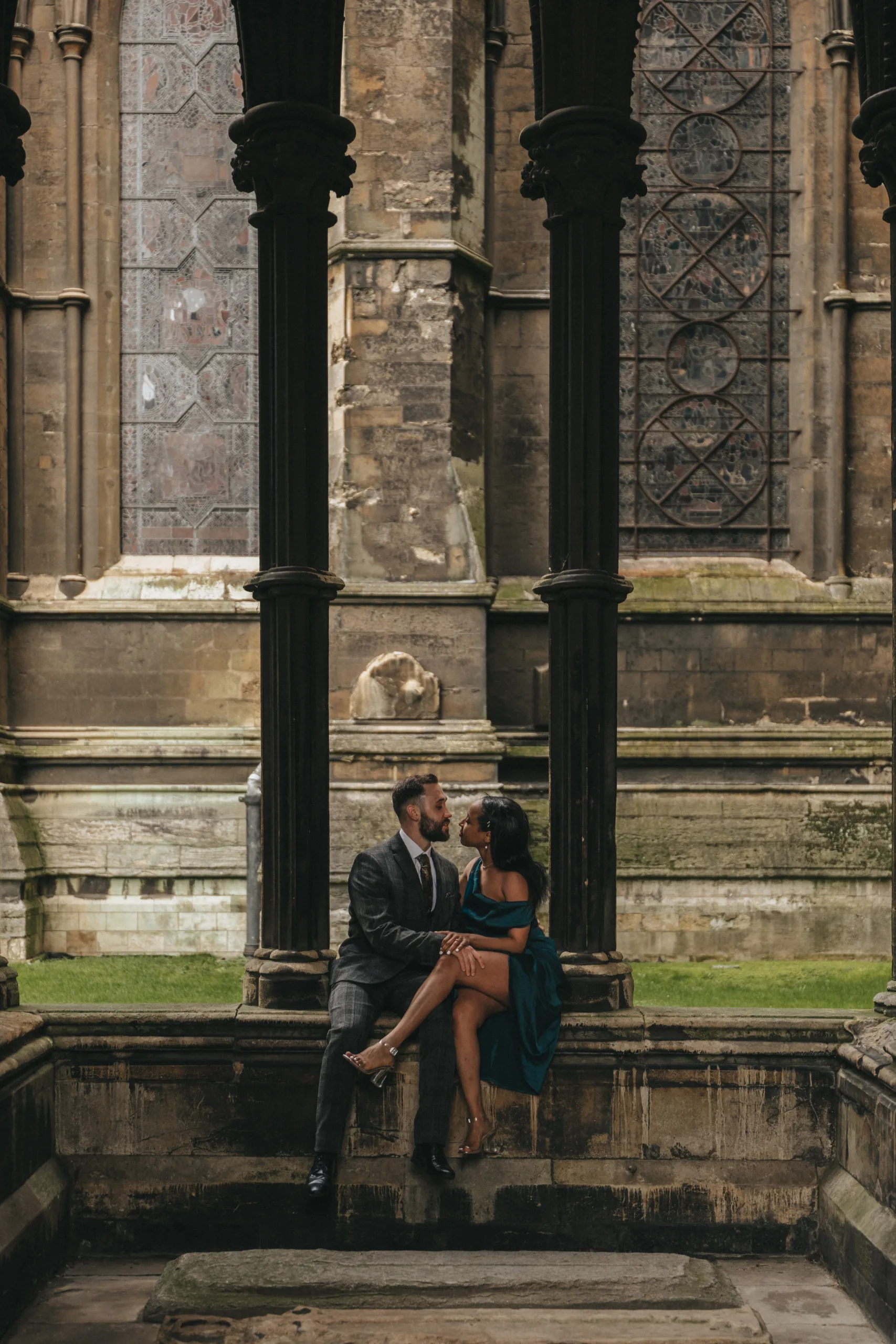 A couple, captured by a photographer, sits on a bench in front of a cathedral in Yorkshire.