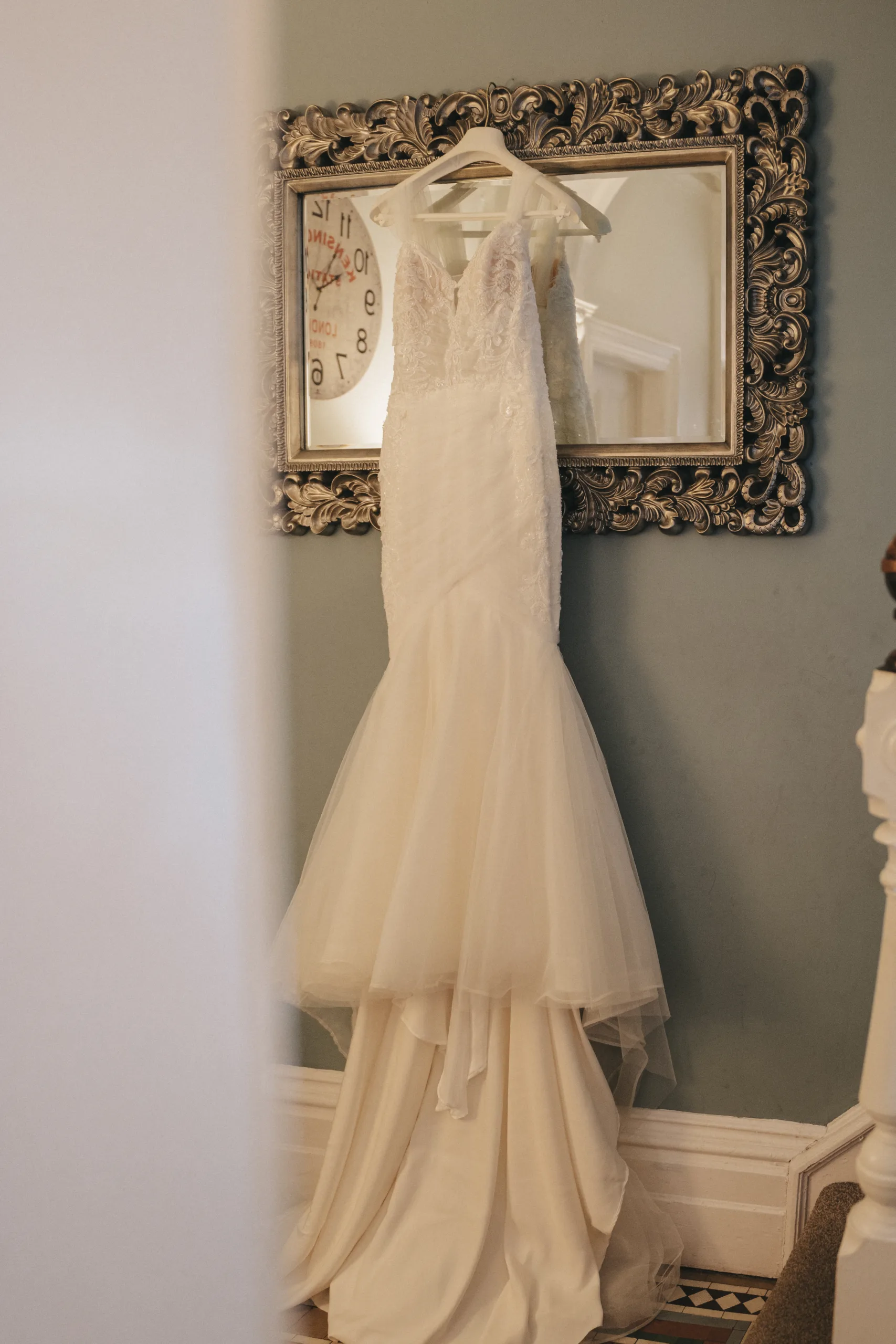 A wedding dress hanging in front of a mirror, captured by a Lincolnshire photographer.