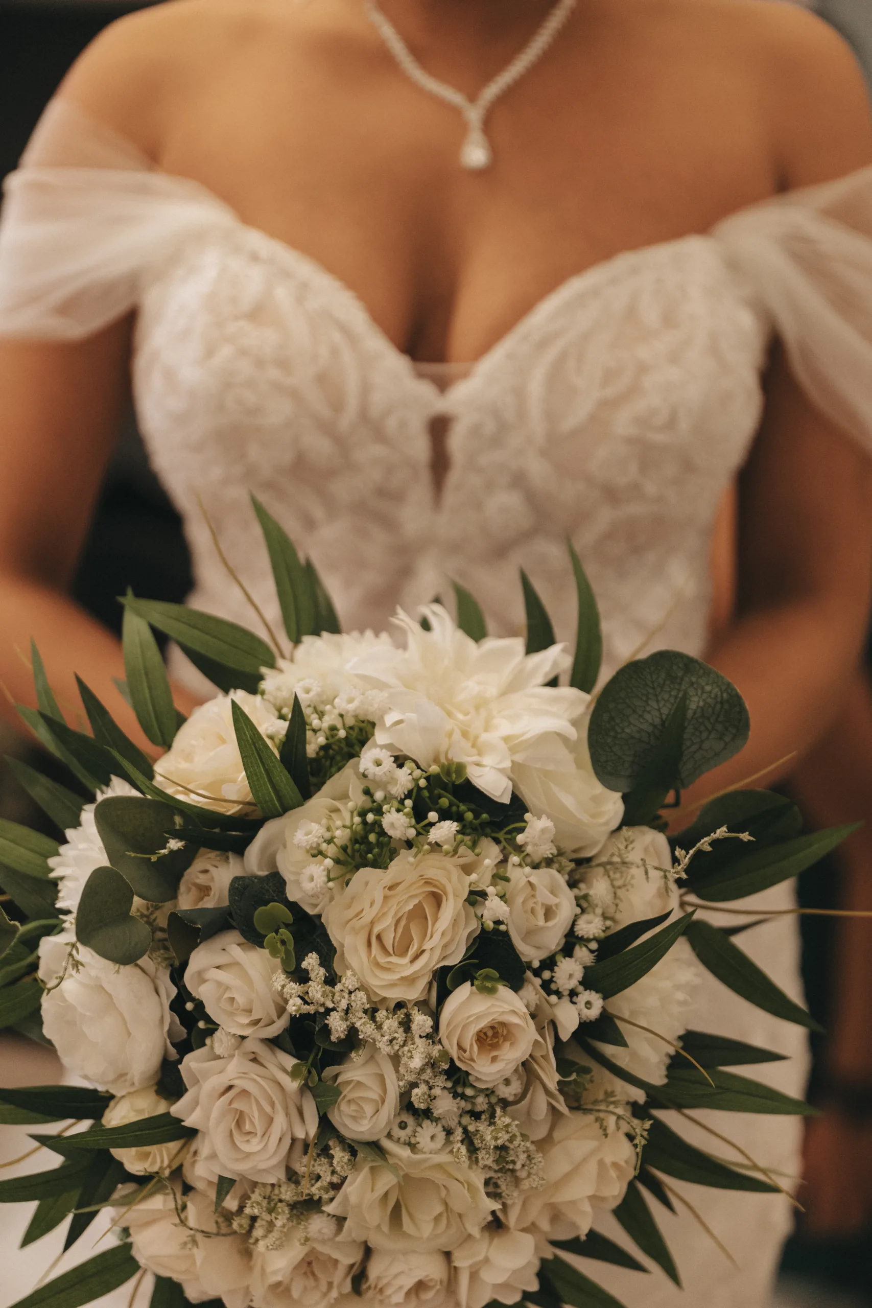 A bride holding a bouquet of white flowers on her wedding day in Yorkshire.