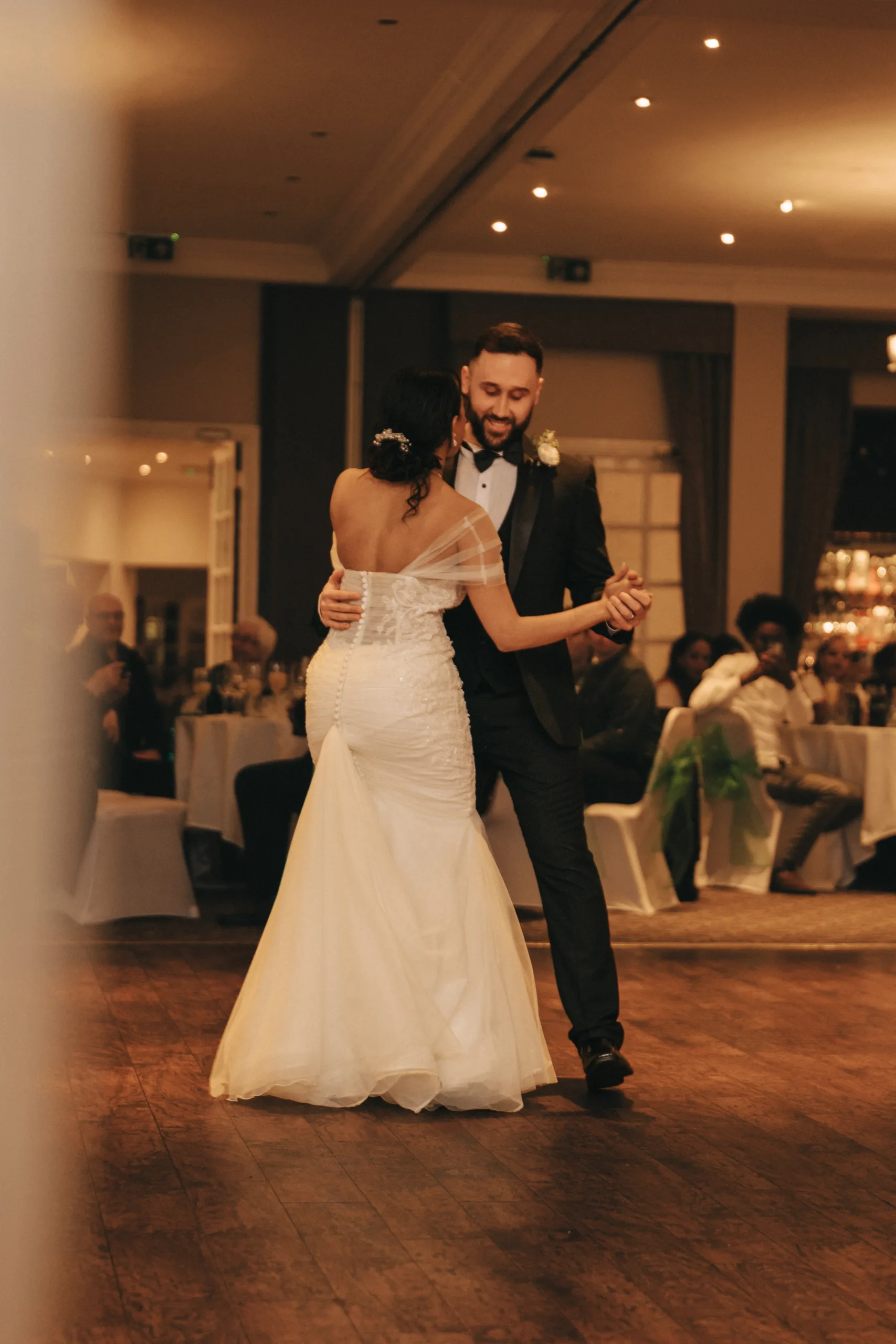 A bride and groom sharing their first dance at a Yorkshire wedding reception, captured by a photographer.