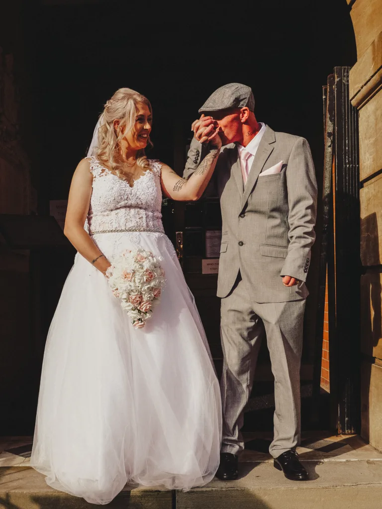 A bride and groom standing in front of a building captured by a photographer in Lincolnshire.