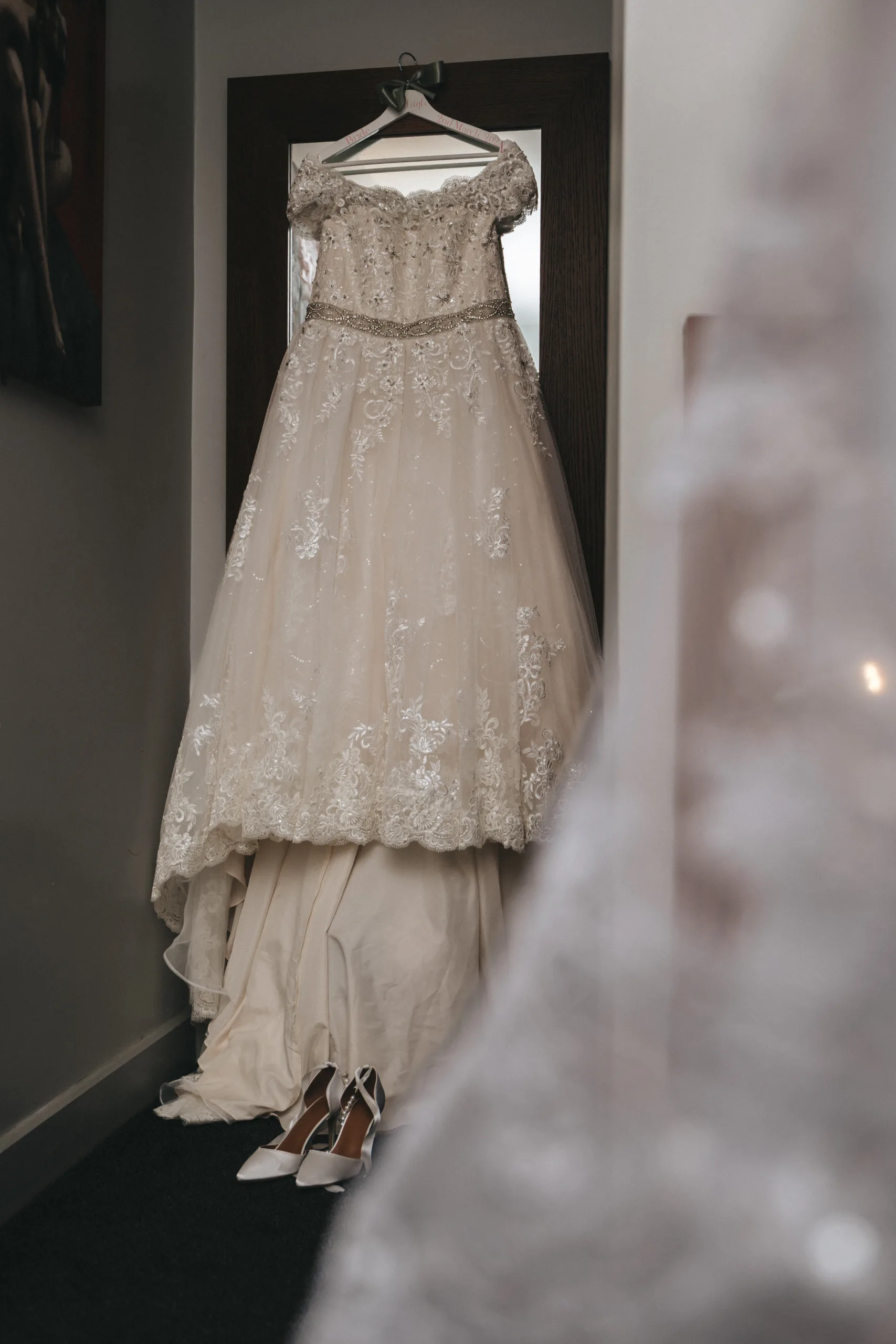 A wedding dress hanging in a doorway.
