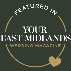 A dark green circular badge with gold accents reads "FEATURED IN YOUR EAST MIDLANDS WEDDING MAGAZINE 2025." A gold heart at the bottom right adds a celebratory, elegant touch—perfect for showcasing in your Page Footer. © Aimee Lince Photography - Wedding photographer in Lincolnshire, Yorkshire & Nottinghamshire